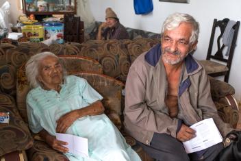 Jaime Luis Caraballo Padilla and his mother, Dolores, sit in the living room of their house after receiving cash and a water filter from Mercy Corps. Jaime says they need “everything” after the storm, but he’ll spend at least a little on his mom—one of her favorite things is to go on drives through the mountains with him. “If I leave, sometimes she gets up and walks away, so I might put her in the car and go out for a drive,” he says.