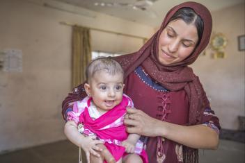 Diana (right) shares a shelter with her husband, Hatem, his parents, their two baby daughters Sidra and Asil, and several other family members. The house is standing, but badly damaged. With cash from Mercy Corps, the couple purchased clothes, food and milk for Sidra, who has a disability and can’t eat solid food.