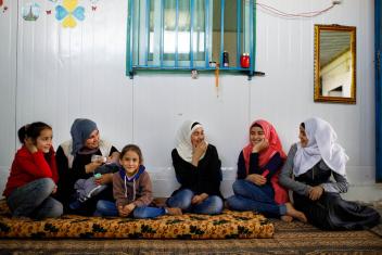 Baby supplies are tremendously helpful for growing refugee families like Eman’s (blue headscarf). She lives in a caravan in Zaatari with her newborn, Inas, and her other children. Photo: Annie Sakkab/Mercy Corps