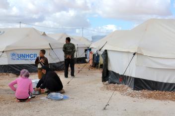 A mother settles into a semblance of a daily routine as she washes dishes after a meal. Families in Za'atari receive tents, mattresses, blankets, cooking pans and utensils, food and water.