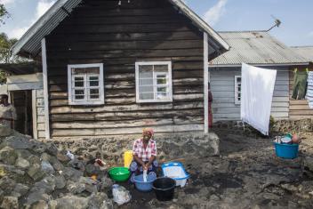 Jacqueline, 37, washes clothes outside her home where Noella leads the women's social mobilization group.