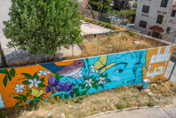 The figure of this mural embodies water and is surrounded by jasmine, the black iris, and the Sinai rosefinch by artists Yazan Mesmar and Miramar Al-Nayyar.