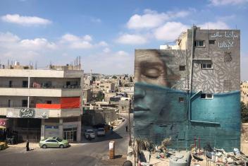 To highlight the intergenerational impact of a water crisis, artists Jonathan Darby and Wesam Shadid rendered an aging face resting above, while the younger face sits below the declining water level emphasizing the dwindling resource in this mural in Irbid.