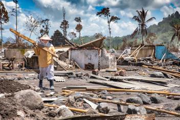 Lasiati salvages what she can find from her family’s home, after Mt. Semeru erupted in Indonesia. Mercy Corps responded by providing her and her neighbours with cooking supplies.