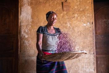 Jeannette sorts beans inside her home. After receiving financial and business training from our team in the Democratic Republic of Congo, she’s increased her income.
