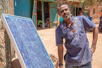 Ahemdnur, a shop owner in Ethiopia, uses a solar panel to charge cell phones. Mercy Corps brings clean energy to communities to improve socioeconomic outcomes and access to food, water, and more.