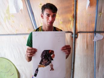 A young man pictured holding his collage.