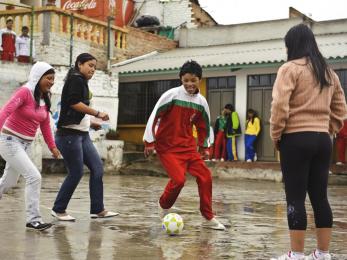 Colombian children playing soccer in the rain