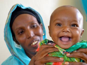 Close up of a smiling baby with mother