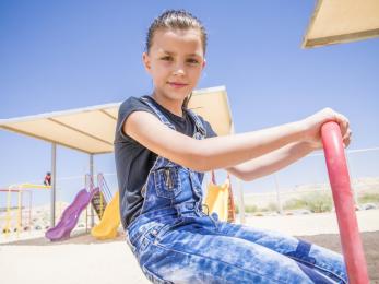 8-year-old majeda, a syrian refugee, playing on a playground
