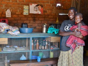 Grace stands with her daughter in her retail shop, now the only dealer of high-quality seeds in her rural area in northern uganda. photo: caitlin turnbull/mercy corps
