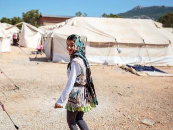 Girl in greece walking near white tents