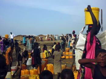 People gathered around water and supplies
