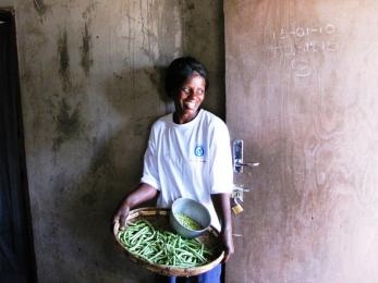 Beauty jokonya, a local farmer in zimbabwe's murehwa district, with bounty from her crop field — which, with help from mercy corps, she and her husband irrigate with a treadle pump.