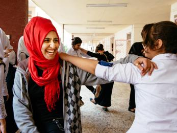 Youth smiling and holding each other by the arm