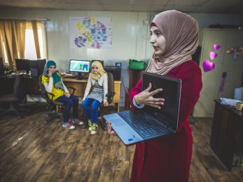 A woman showing a laptop computer to a group