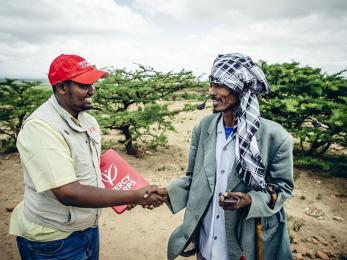 Mercy corps employee shaking hands with a program participant