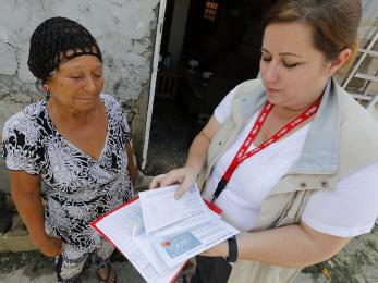 Mercy corps employee working with woman aid recipient. 