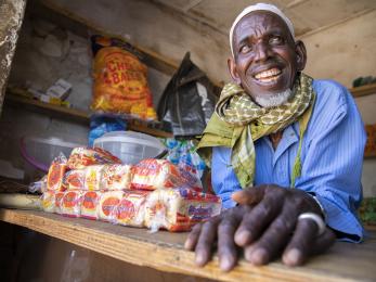 Nigerian man seated at a table smiling at the camera