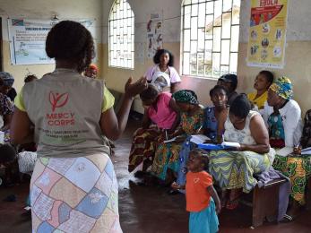 Mercy corps team member speaking to group of people