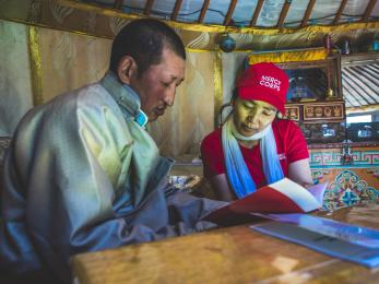 Mercy corp team member reviewing materials with community member