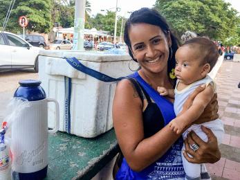 Elisa, a venezuelan migrant to colombia sells water and coffee in a park with her newborn child. photo: ana maria olarte/mercy corps
