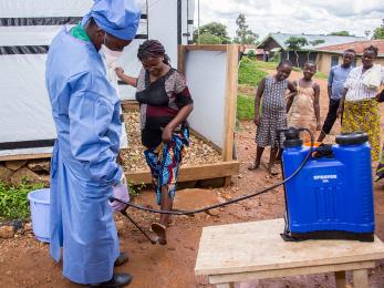 Mercy corps supports the malepe health center in drc with chlorine and hand washing kits to disinfect hands before entering. this measure is very effective for the prevention of ebola. kavira, 23, pregnant with her first child, comes to the health center for an antenatal clinic. her feet are disinfected before entering. photo: rudy nkombo/mercy corps