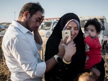 Family talking on phone in hasansham camp