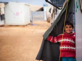 Smiling boy looking out from shelter