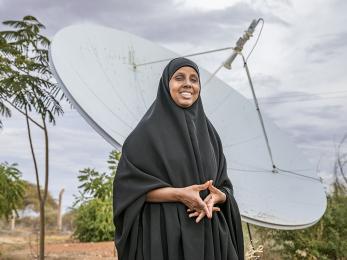 Woman standing in front of a large satellite