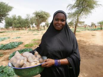 Woman holding produce in field