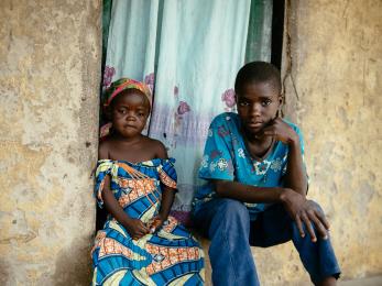 Girl and boy sitting next to each other and looking at the camera