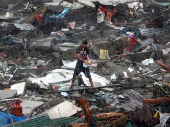 A person is pictured standing in a salvage yard in a rainstorm