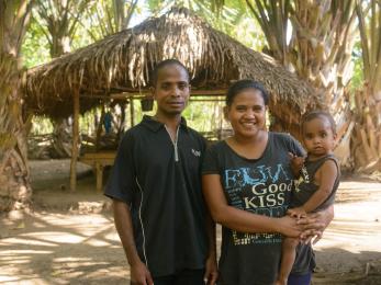 A man and woman holding a baby in timor leste