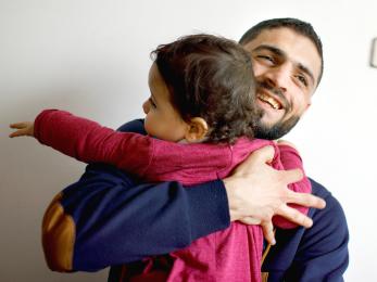 Father hugging child.