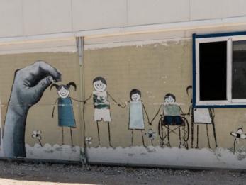 A wall painted with a mural of children holding hands.