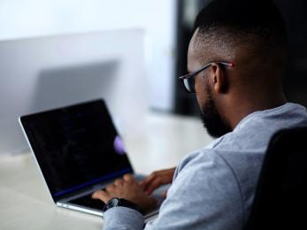 A person sits at a laptop computer.