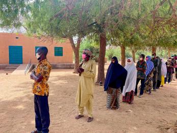 People line up six feet apart to keep from spreading covid-19. 