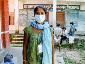 A person faces the camera while wearing a face mask. 