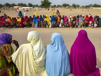 Women and children wait in line for a monthly food distribution in fulatari camp.