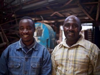 Two individuals stand next to each other and smile for the camera.