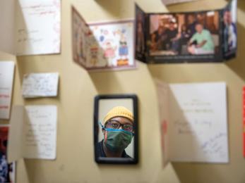 On a wall inside a small storage room a person looks at the various greeting cards he and his father have received from their clients over the years.
