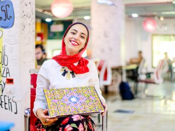 Eman, a freelance medical translator and graduate of mercy corps' gaza sky geeks freelance training, with her laptop