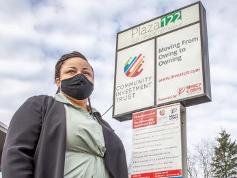 A person standing outside a neighborhood commercial-retail space. 