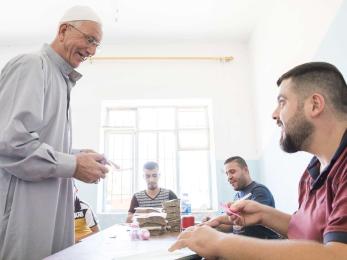 Hayder shalash aboudi, 62, receives a cash distribution from mercy corps. 