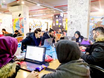 Young people working in an office place together.