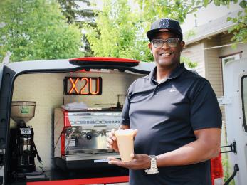 Eddy holford holding beverages he made with his mobile café business vehicle.