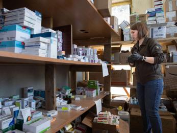 A person in a warehouse pulling medicine to send to people trapped by the war in eastern ukraine. 