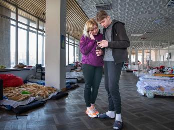 Two people reading a text message on a mobile device.