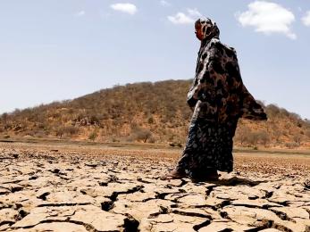 A person walking on dried earth.